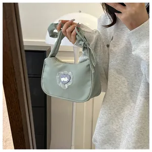 Gros plan détaillé d'un sac à main en toile vert menthe avec écusson lapin et cœur