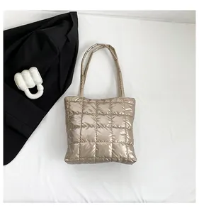 Macro shot of champagne gold quilted tote bag with metallic texture and sleek stitching