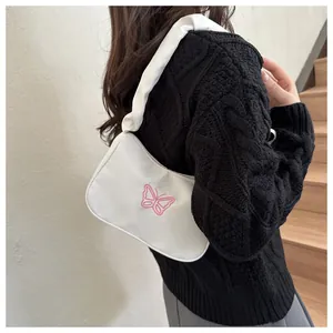 Detalle de bolso blanco con bordado de mariposa rosa y asa plisada de estilo coreano