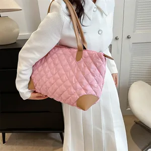 Vue détaillée du sac cabas rose matelassé avec poignées et finitions en cuir marron