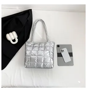 Silver quilted tote bag with square stitching shown with commuting essentials