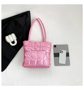 Close-up of pink quilted tote bag with square stitching and glossy metallic finish