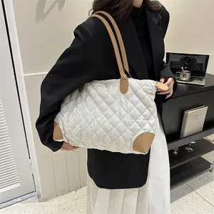 Gros plan sur le sac cabas en nylon matelassé avec garniture en cuir et bandoulière