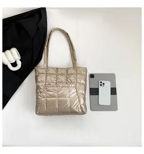 Detail of champagne gold quilted tote bag with glossy finish and square stitch pattern