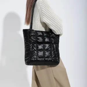 Fashionable black quilted tote bag with large square stitching and puffer material texture