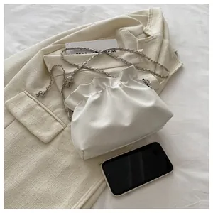 Détail du sac seau plissé blanc avec chaîne argentée et boule de réglage en métal