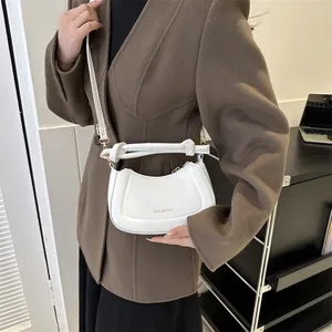 Détail du sac à bandoulière en cuir blanc avec poignée nouée et texte Tidal Dryness