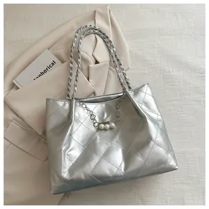 Detail of silver quilted tote bag with metallic chain handles and white pearl charms