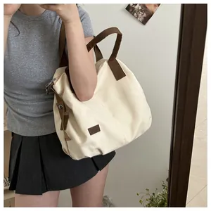 Canvas tote bag in cream and brown styled on a person for actual size and texture detail
