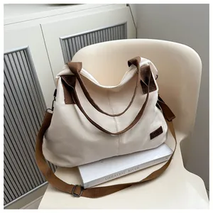 Detail of canvas tote bag with brown straps, fashion leather patch and large capacity