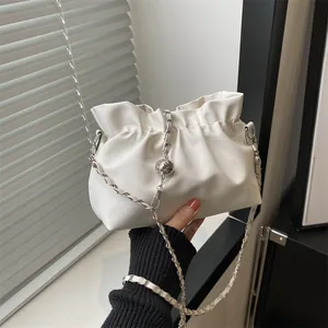 Détail du sac nuage plissé blanc avec bandoulière chaîne et boule en métal poli
