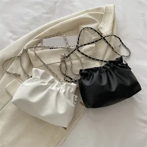 Gros plan de sacs seaux nuages noirs et blancs avec bandoulière sur blazer beige