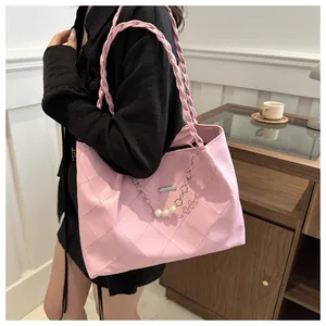 Detailed shot of pink quilted tote bag with pearl and silver chain embellishments