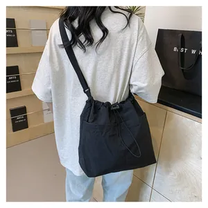 Detailed back view of minimalist black drawstring crossbody bag with adjustable strap