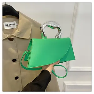 Detail der hellgrünen geometrischen Handtasche mit elegantem silbernem Metallgriff