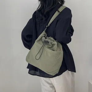 Olive green large capacity crossbody bag with drawstring closure and wide strap
