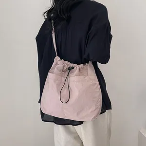 Pink drawstring crossbody bag for women made of lightweight nylon with large pockets