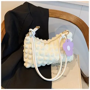Detail of white bubble texture cloud bag with purple flower charm and golden zipper