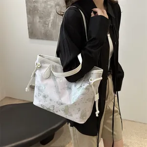 Sac fourre-tout blanc avec imprimé papillon et cordon de serrage sur un mannequin
