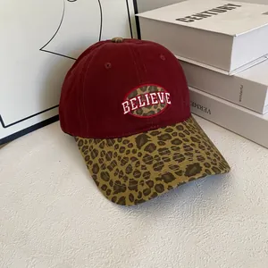 Detail of burgundy baseball cap featuring leopard print brim and Believe patch embroidery