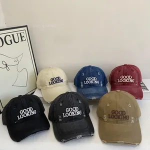 Macro shot showing distressed vintage cotton baseball caps with Good Looking embroidery