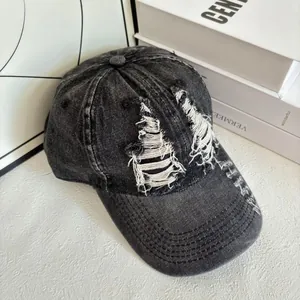 Dettagli usurati e strappati della cuffia da baseball in denim nero lavato stile street