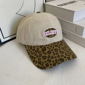 Beige baseball cap with leopard brim and pink Believe embroidery in street style