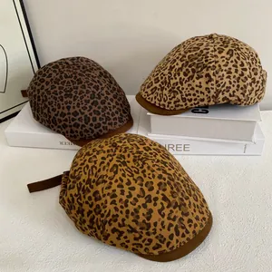 Fashionable leopard print newsboy cap with stylish leather brim for women shown in white setting