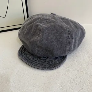 Detailed texture of dark grey washed denim newsboy cap with vintage stitching accents