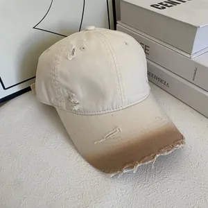 Close-up of vintage pink baseball cap with distressed torn edges and faded brim detail
