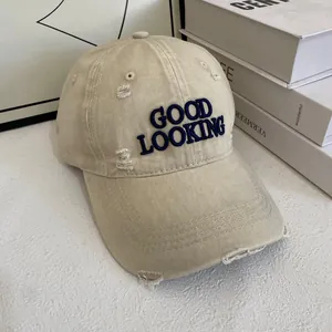 Distressed beige baseball cap with GOOD LOOKING embroidery and ripped details
