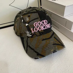 Macro detail of pink 3D embroidery on camouflage vintage distressed baseball cap