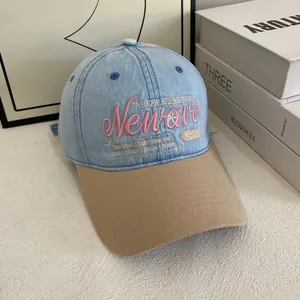 Close-up of pink 3D embroidery and denim fabric detail on a two-tone baseball cap