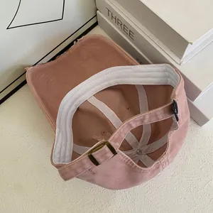 Detail of adjustable metal buckle and distressed brim on pink cotton baseball cap