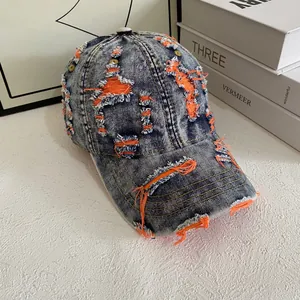 Vintage distressed denim baseball cap with orange lining and ripped street style details