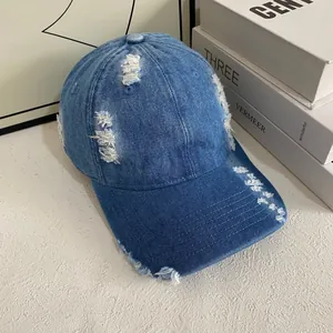 Casquette de baseball vintage en denim bleu délavé avec détails usés sur fond blanc