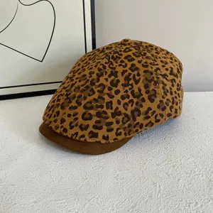 Detail of leopard print pattern fabric and brown leather brim of the stylish newsboy cap