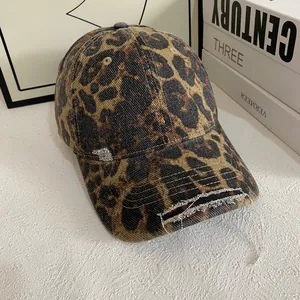 Close-up of pink leopard print baseball cap with distressed brim and frayed edge details