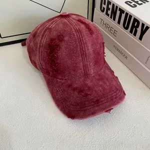 Detail einer weinroten gewaschenen Denim-Baseballkappe mit Vintage-Fransenkanten