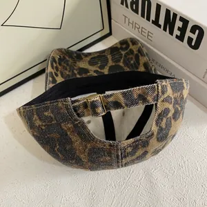Detail view of pink leopard print baseball cap with adjustable bronze metal buckle