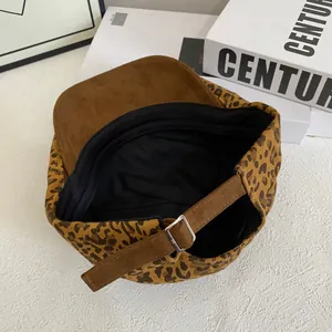 Detail view of leopard newsboy cap showing adjustable leather strap and inner lining