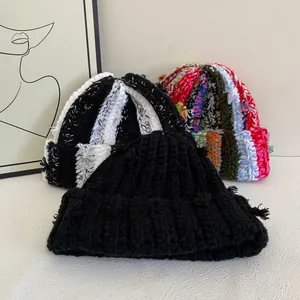 Macro shot of colorful striped handmade knit beanies with thick yarn textures