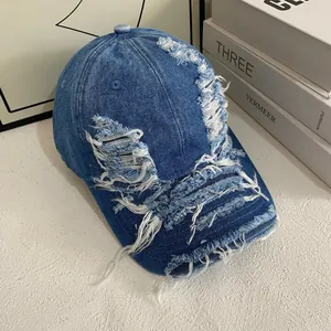 Distressed blue denim baseball cap with vintage frayed holes and fringe details