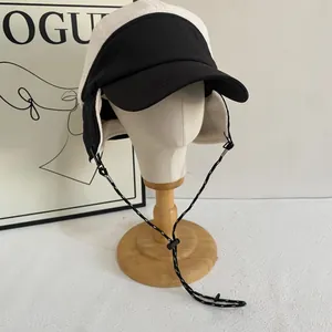 Detail of color-block winter trapper hat featuring fleece ear flaps and windproof drawstrings