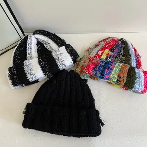 Handmade striped knit beanies in various colors featuring trendy fringe detailing