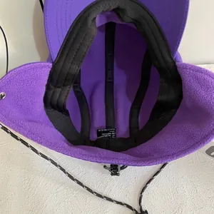 Detail shot of purple fleece lining and adjustable windproof cord on a thermal earflap hat