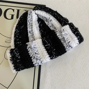 Detailed view of thick knit vertical stripes and texture on a monochrome beanie hat