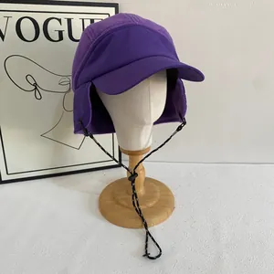 Purple fleece earflap hat with polka dot drawstrings on a white display head stand