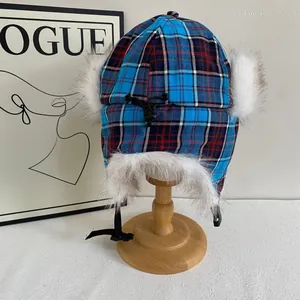 Détail du bonnet d'aviateur à carreaux bleus avec doublure en fausse fourrure blanche