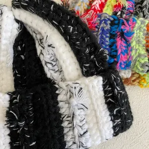 Close-up of handmade chunky knit texture with black and white stripes on beanie hat